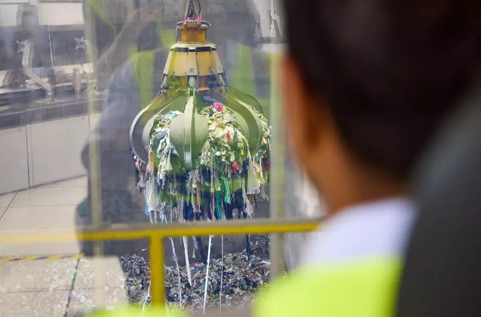 An employee at the controls of a waste grapple for incineration